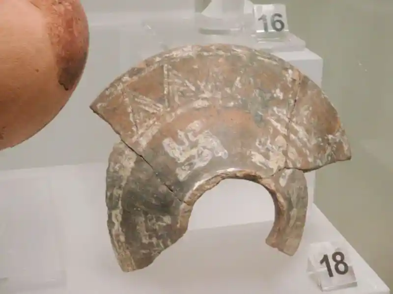 Clay lid with swastikas and sun rays surrounding a circle